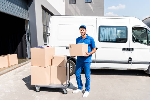 delivery man with box and cart next to van